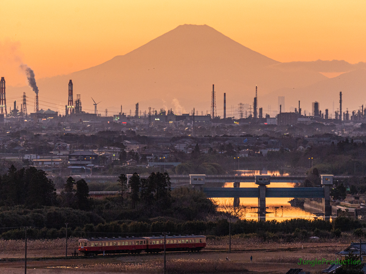 夕映えに浮かび上がる影富士をバックに小湊鉄道の列車が走る